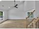 Open living room featuring hardwood floors, a vaulted ceiling, and a modern ceiling fan at 2601 Garland Way, Duluth, GA 30096
