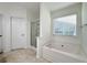 Bright bathroom features a soaking tub with tiled flooring, and a glass enclosed shower at 2642 Colleen Ln, Dacula, GA 30019
