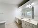 Elegant bathroom with double sink vanity and a large mirror, natural light coming from the window at 2642 Colleen Ln, Dacula, GA 30019