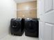 Convenient laundry room with modern front-load washer and dryer, plus overhead shelving for easy storage at 2642 Colleen Ln, Dacula, GA 30019