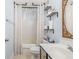 This secondary bathroom has a shower/tub combo and shelving for storage at 4348 Tillage Path, Douglasville, GA 30135