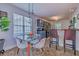 Open eat-in kitchen area with glass table, modern chairs, pendant lighting, and bar stool seating at 4348 Tillage Path, Douglasville, GA 30135
