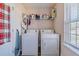 Functional laundry room with washer, dryer, shelving and a window for natural light at 4348 Tillage Path, Douglasville, GA 30135