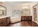 Large bathroom with dual vanities, soaking tub, hardwood floors, and lots of natural light at 5161 Hermitage Dr, Powder Springs, GA 30127