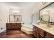 Bright bathroom with dual sinks, soaking tub, wood cabinets, and natural lighting at 5161 Hermitage Dr, Powder Springs, GA 30127