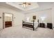Bright bedroom with tray ceiling, carpet, and ensuite bathroom entrance at 5161 Hermitage Dr, Powder Springs, GA 30127