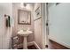 Charming powder room features unique wallpaper, pedestal sink, and hardwood floors at 5161 Hermitage Dr, Powder Springs, GA 30127