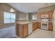 Functional kitchen with wooden cabinetry, view to living area, and standard white appliances at 580 Camry Cir, Dallas, GA 30157