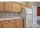 Kitchen with wooden cabinets, white refrigerator, and neutral countertops at 580 Camry Cir, Dallas, GA 30157