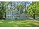 Charming two-story home with a well-manicured lawn, lovely front porch, and beautiful mature trees at 800 Post Road Cir, Stone Mountain, GA 30088