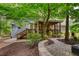 Inviting backyard featuring a covered porch, stone patio, and lush landscaping at 2165 Robin Hood Trl, Cumming, GA 30040