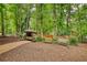 Lush backyard with seating, swing, storage shed, and mature trees at 2165 Robin Hood Trl, Cumming, GA 30040