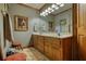 Bright bathroom featuring double sinks, wood cabinetry, and a large mirror for easy morning routines at 2165 Robin Hood Trl, Cumming, GA 30040