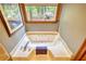 Large soaking tub bathed in natural light with a serene view of the backyard and shed at 2165 Robin Hood Trl, Cumming, GA 30040