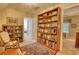 Book-lined room showcases built-in shelving, display cabinet and a cozy sitting area with ample natural light at 2165 Robin Hood Trl, Cumming, GA 30040