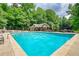 Community pool with a seating area and lush landscaping at 2165 Robin Hood Trl, Cumming, GA 30040