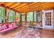 Cozy screened porch with wood floors, comfortable seating, and views of the beautiful green backyard at 2165 Robin Hood Trl, Cumming, GA 30040
