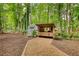 Quaint storage shed in the backyard with gravel path and surrounding greenery at 2165 Robin Hood Trl, Cumming, GA 30040