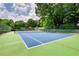 Community tennis court with new surface surrounded by lush greenery at 2165 Robin Hood Trl, Cumming, GA 30040