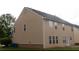 Back view of a home featuring beige siding and multiple windows with a trimmed lawn at 3292 Shady Valley Ct, Loganville, GA 30052