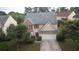 Aerial view of a two-story home featuring a two-car garage, and mature trees in a residential neighborhood at 3292 Shady Valley Ct, Loganville, GA 30052