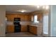 Bright kitchen area with wooden cabinets, black appliances, and lots of natural light at 3292 Shady Valley Ct, Loganville, GA 30052