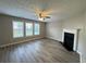 Living room with a fireplace, ceiling fan, and multiple windows providing natural light at 3292 Shady Valley Ct, Loganville, GA 30052