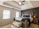 Spacious main bedroom featuring a tray ceiling, ceiling fan, and carpet at 161 Honey Creek Rd, Mcdonough, GA 30252