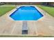 Clear blue swimming pool with diving board surrounded by a concrete deck and green lawn at 161 Honey Creek Rd, Mcdonough, GA 30252