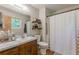 Neutral bathroom with a single sink vanity, open shelves, and a shower/tub combo at 2642 Bridgehampton Sw Rd, Marietta, GA 30064