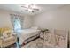 Bright bedroom features a chair, a single bed, a crib, and a patterned rug, designed for comfort and relaxation at 2642 Bridgehampton Sw Rd, Marietta, GA 30064