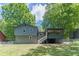 Back exterior showcasing screened in porch, large yard, and mature trees at 2642 Bridgehampton Sw Rd, Marietta, GA 30064
