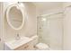 Bright bathroom with a glass enclosed shower, white tile, vanity, and oval mirror at 2742 Alpine Rd, Atlanta, GA 30305