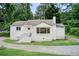 Charming white brick home with mature trees, a small front porch and a paved driveway at 2742 Alpine Rd, Atlanta, GA 30305