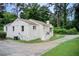 White brick home with an extended driveway, small front porch and mature trees in a landscaped yard at 2742 Alpine Rd, Atlanta, GA 30305