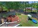Large wooded backyard includes a play area, firepit and a trampoline at 3856 Nowlin Nw Rd, Kennesaw, GA 30144