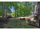 Spacious backyard with mature trees, play equipment and a fire pit seating area at 3856 Nowlin Nw Rd, Kennesaw, GA 30144