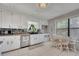 Well-lit kitchen featuring white cabinets, stainless steel appliances, and an adjacent breakfast nook with natural lighting at 3856 Nowlin Nw Rd, Kennesaw, GA 30144
