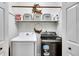Functional laundry room with modern washer and dryer, and ample shelving at 3856 Nowlin Nw Rd, Kennesaw, GA 30144