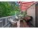 Inviting outdoor porch with comfortable seating, a grill, and a red and white awning at 3856 Nowlin Nw Rd, Kennesaw, GA 30144