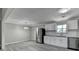 Open kitchen and dining area with stainless steel appliances, white cabinets, and gray flooring at 396 Independence Dr, Jonesboro, GA 30238