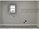 Laundry room features a window, modern flooring, wall-mounted shelving and washer/dryer hookups at 396 Independence Dr, Jonesboro, GA 30238