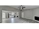 Open concept living room and kitchen with gray floors, a ceiling fan, and a fireplace at 396 Independence Dr, Jonesboro, GA 30238