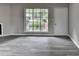 Living room with gray flooring, large window, and white door leading to the exterior of the home at 396 Independence Dr, Jonesboro, GA 30238