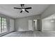 Open living room with ceiling fan, gray floors, and open layout looking into the kitchen at 396 Independence Dr, Jonesboro, GA 30238