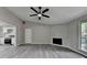 Open-concept living room with gray floors, a ceiling fan, a fireplace, and an adjacent kitchen at 396 Independence Dr, Jonesboro, GA 30238