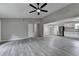 Bright living room with gray walls, gray flooring, a ceiling fan and an open floor plan adjacent to the kitchen at 396 Independence Dr, Jonesboro, GA 30238