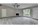 Open concept living room featuring a large window, vaulted ceiling, fireplace, and gray flooring at 396 Independence Dr, Jonesboro, GA 30238