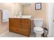 Well-lit bathroom featuring tiled floor, wooden vanity, framed art, and a toilet at 6195 Queensdale Dr, Douglasville, GA 30135