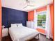 This bedroom features a blue accent wall, window, and a white dresser at 6195 Queensdale Dr, Douglasville, GA 30135